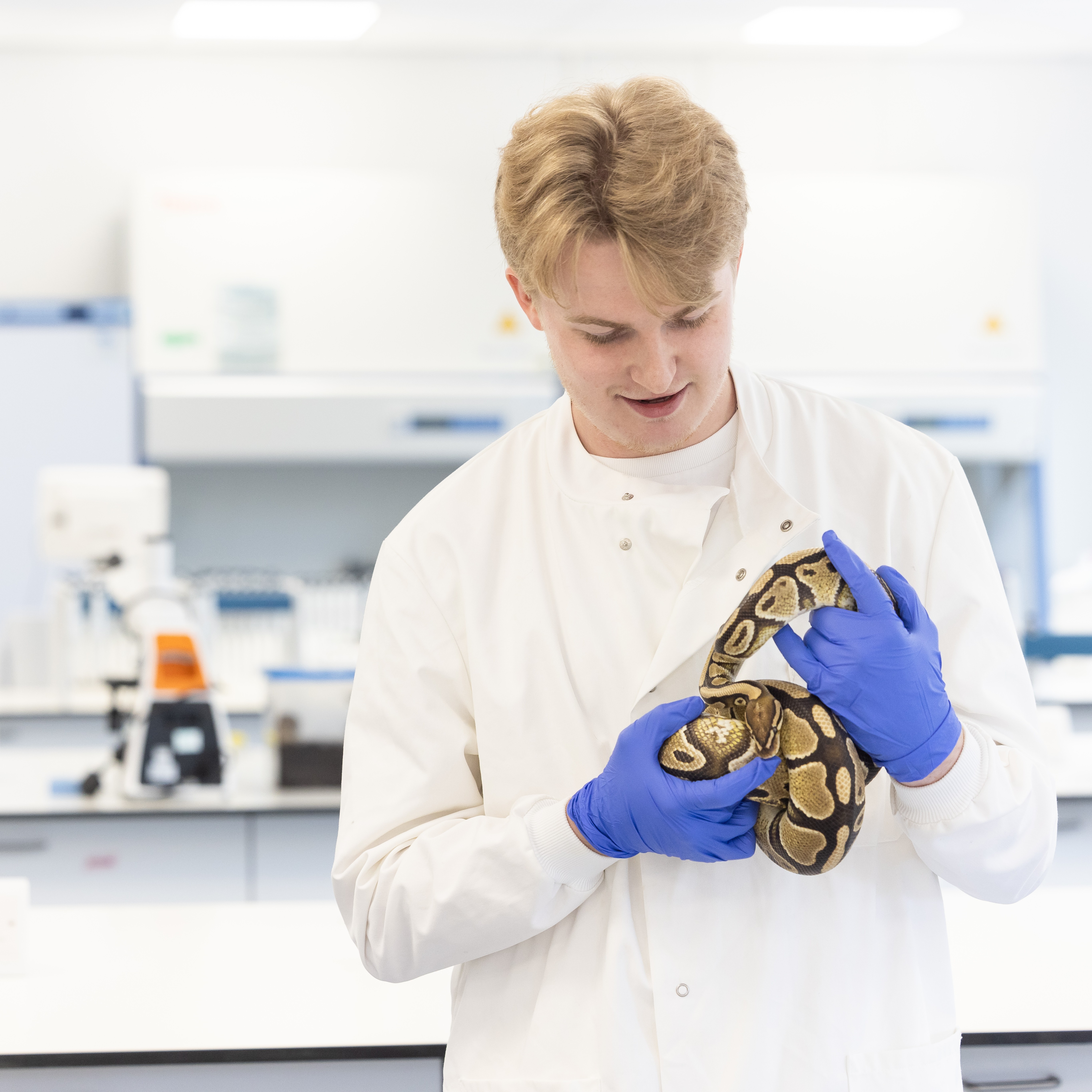 student holding snake in lab