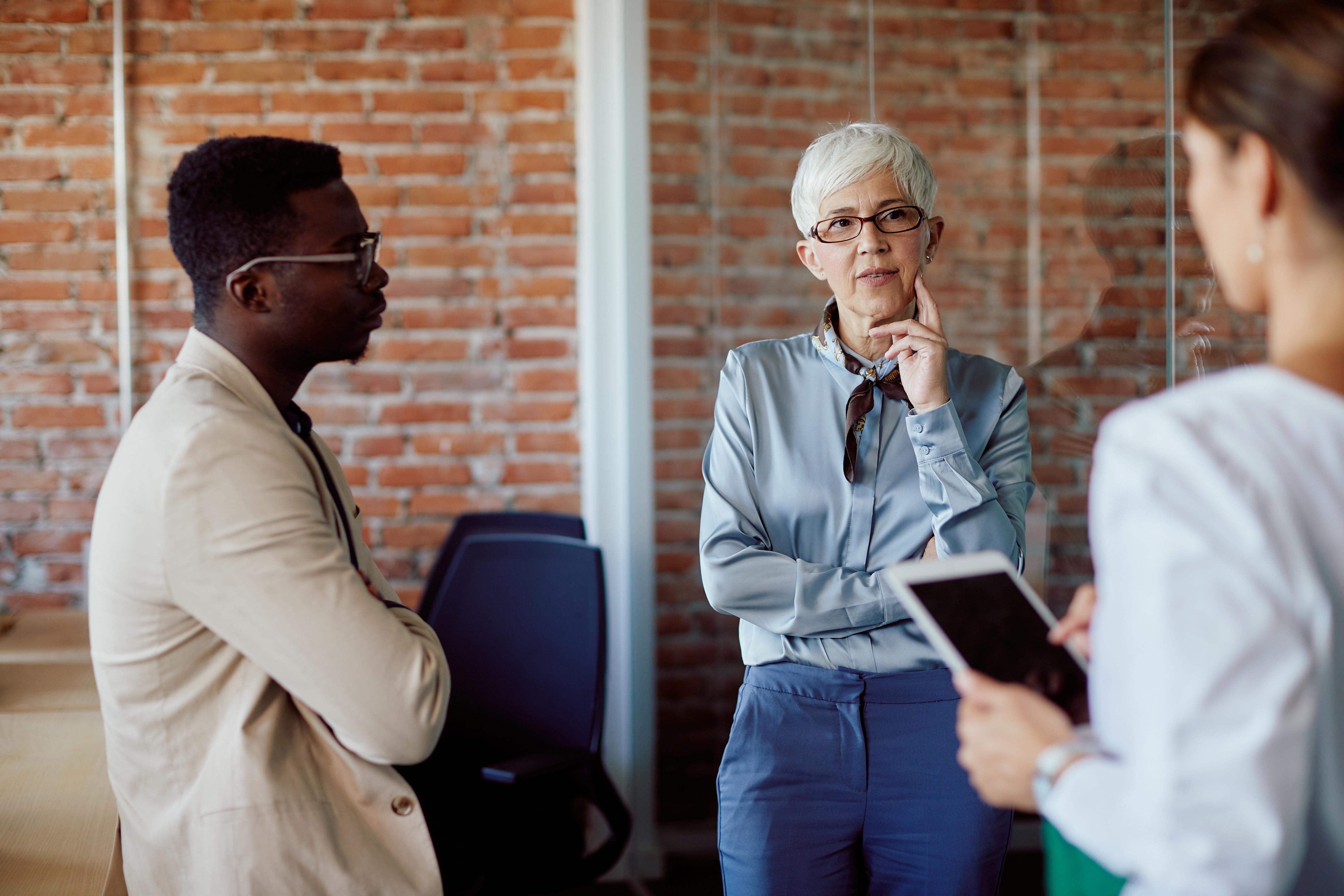 Business professionals collaborating in an office, representing teamwork, leadership, and international communication skills for Business Management and French BA Hons.