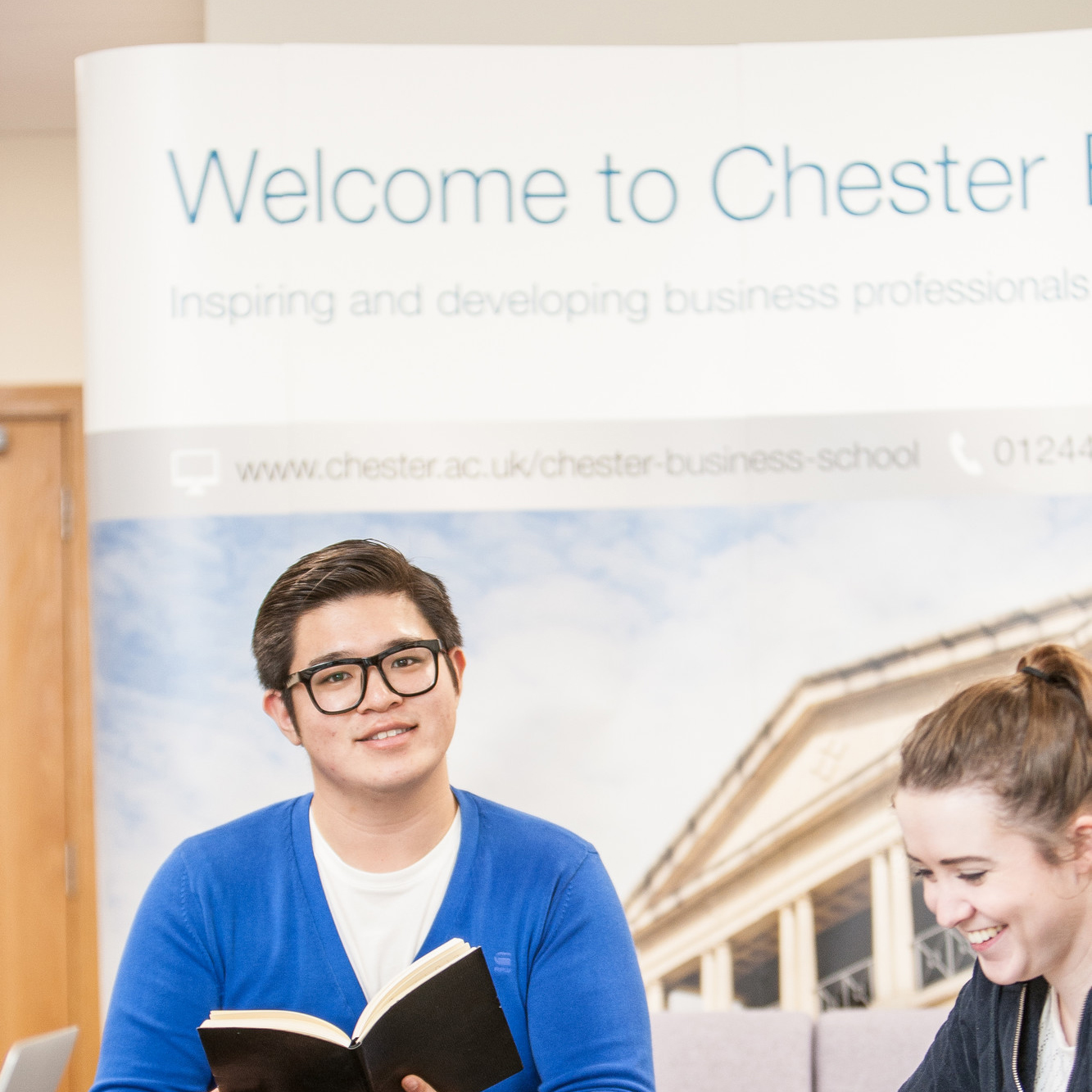 A man and woman at a table, collaborating on research at Chester Business School.