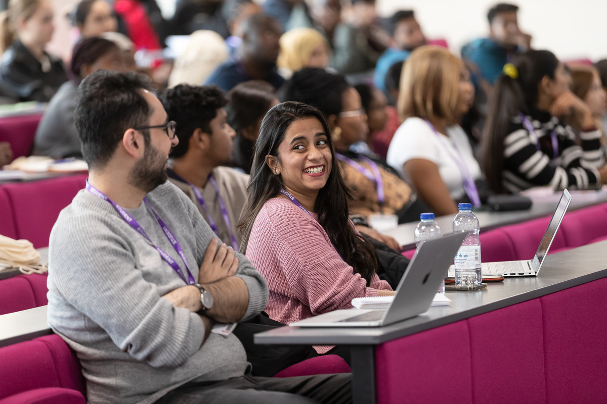 Students seated in a lecture theatre, CBH016, at the University of Chester’s Queen’s Park campus, with laptops and notes on desks.