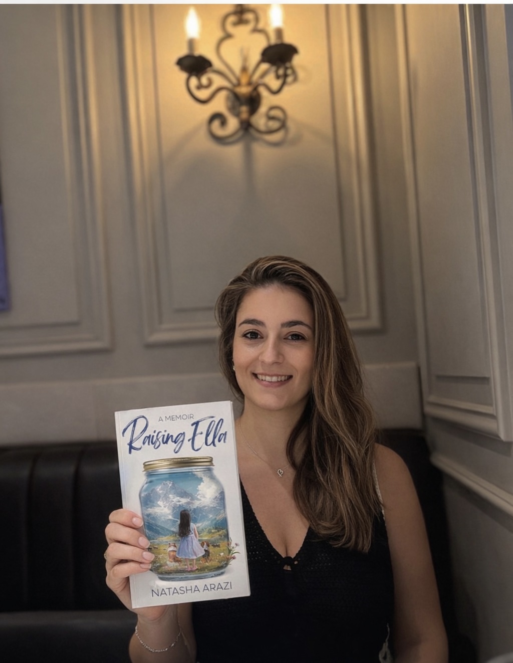 A student holds a book called Raising Ella