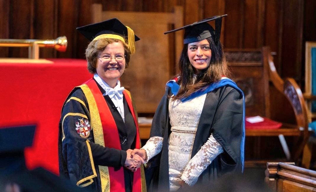 Suraksha shaking hands with University of Chester Vice-Chancellor, Eunice Simmons, at her graduation ceremony