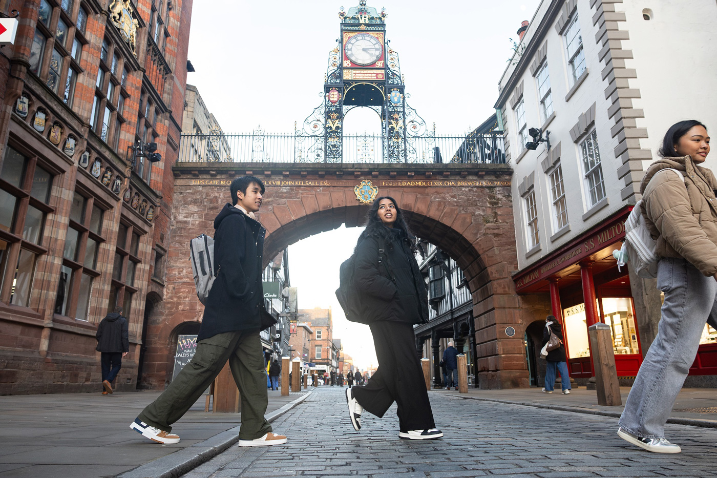 Students walking across the road in front of the Eastgate Clock