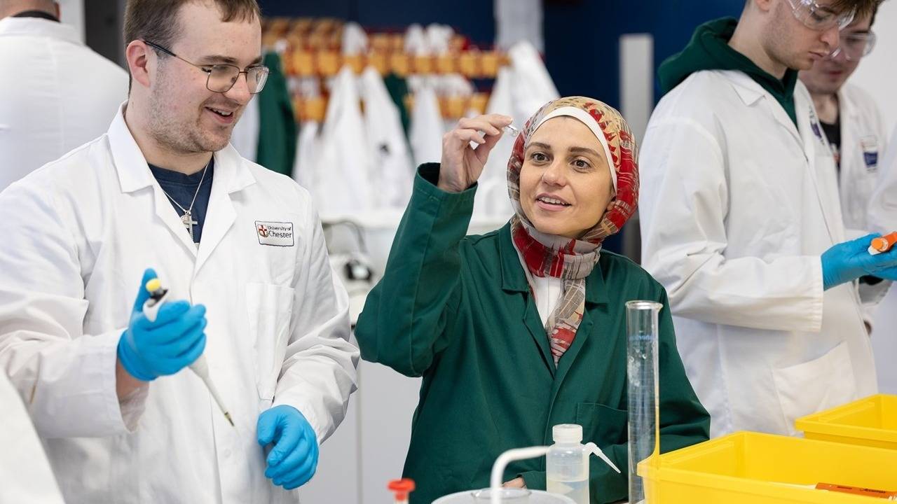 A group of chemistry students and tutor working in a laboratory facility.