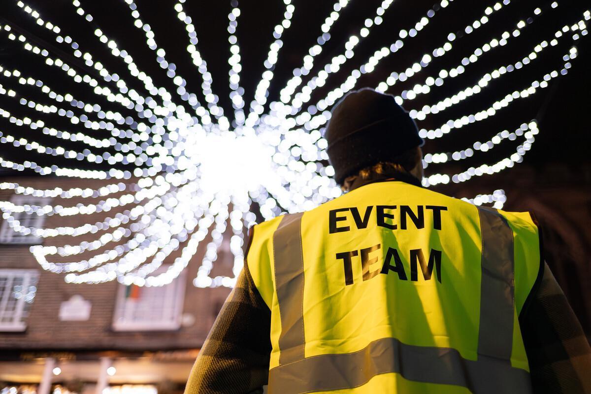 Event team member wearing a high-visibility jacket oversees city centre lights, representing the leadership, organisation, and professionalism developed through the Events Management with Business BA (Hons) degree.