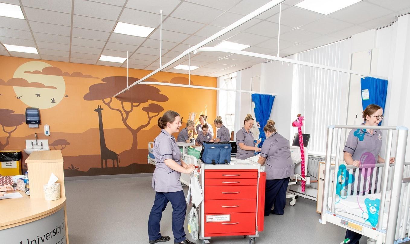 Student nurses practicing paediatric and learning disability care in a simulated hospital ward, developing clinical skills as part of the Learning Disability and Children’s Nursing MNurs (Hons) degree.