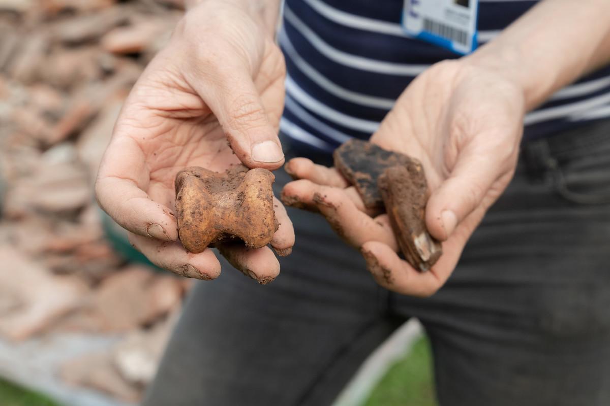 Close-up of archaeological artefacts being carefully examined during a field excavation, highlighting heritage preservation, community engagement and public archaeology research for Public Archaeology MA students at the University of Chester.
