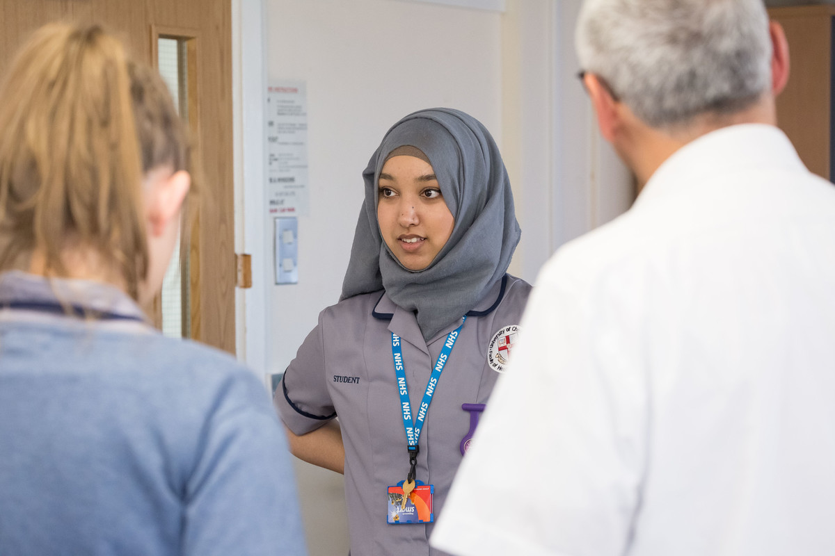student in uniform talking to people