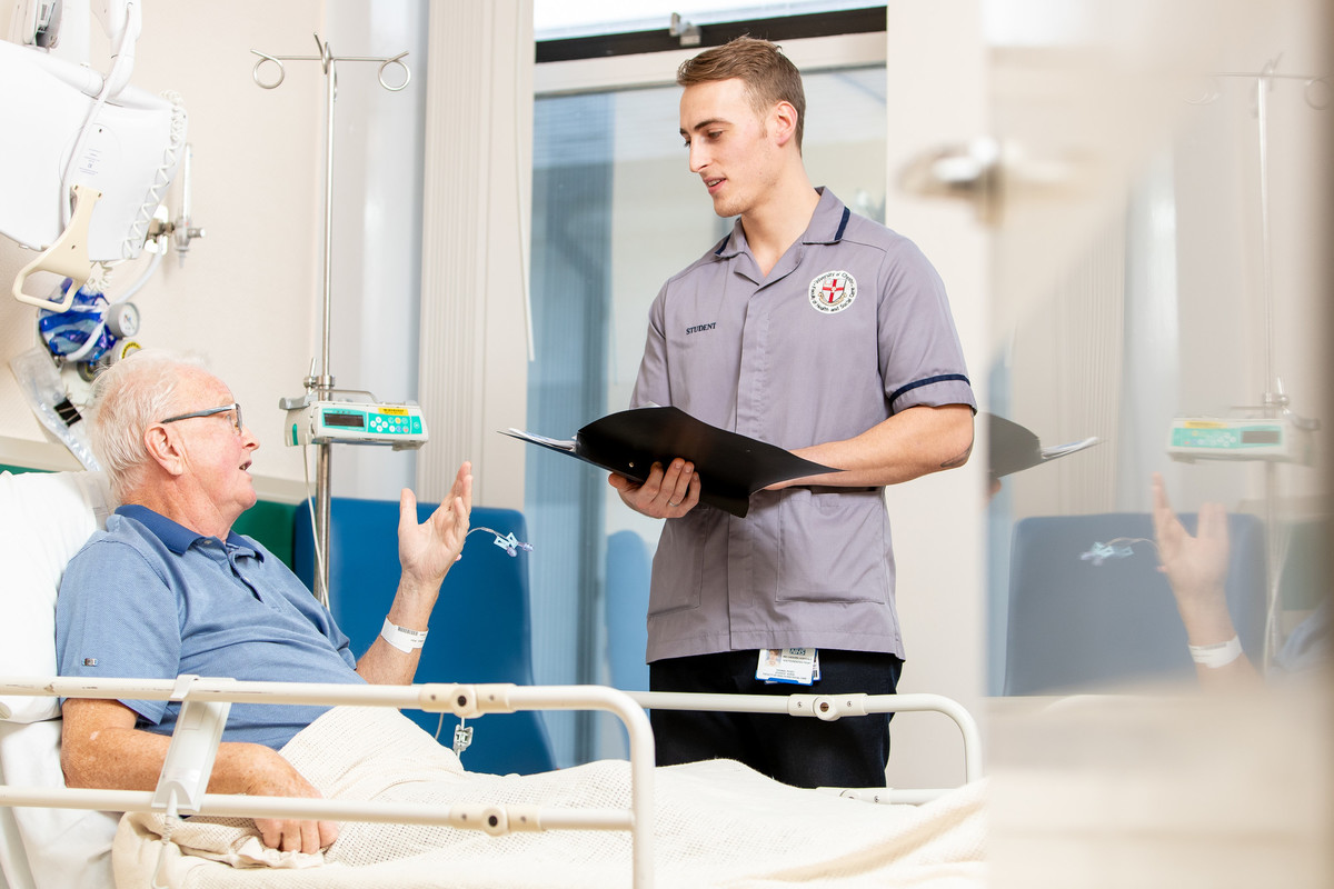 male adult nursing degree student with patient