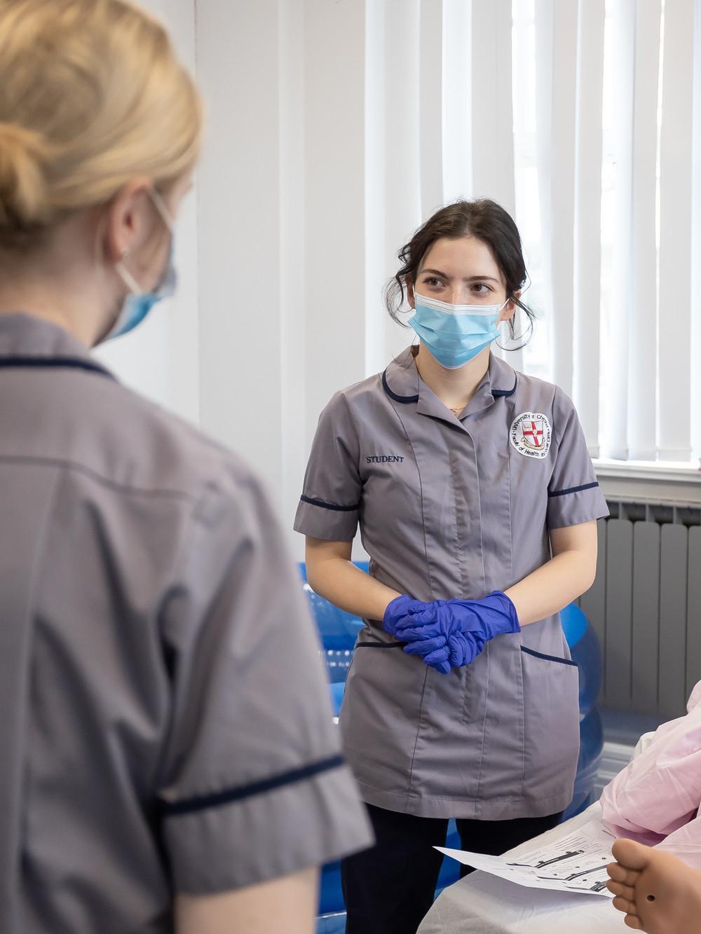 Nursing apprentices take part in clinical simulation training using a patient mannequin in a healthcare skills lab, developing practical patient care and professional skills for the Registered Nurse (Degree Apprenticeship) BN at the University of Chester.