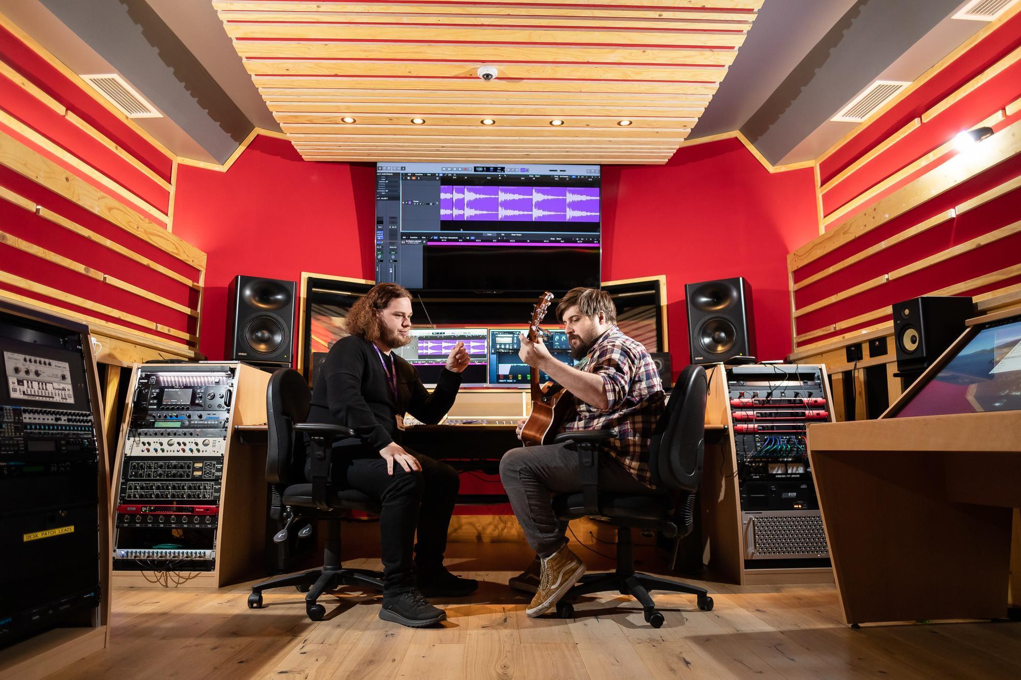 Students working together in a professional recording studio, producing and discussing music tracks as part of the Commercial Music BA (Hons) degree.