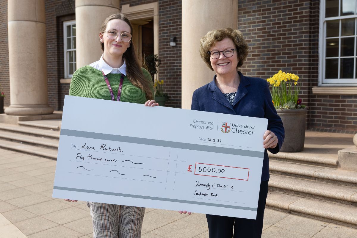 Two people holding a giant cheque for £5,000. On the left is student Luna, on the right is the Vice-Chancellor. Both are smiling and looking at the camera.