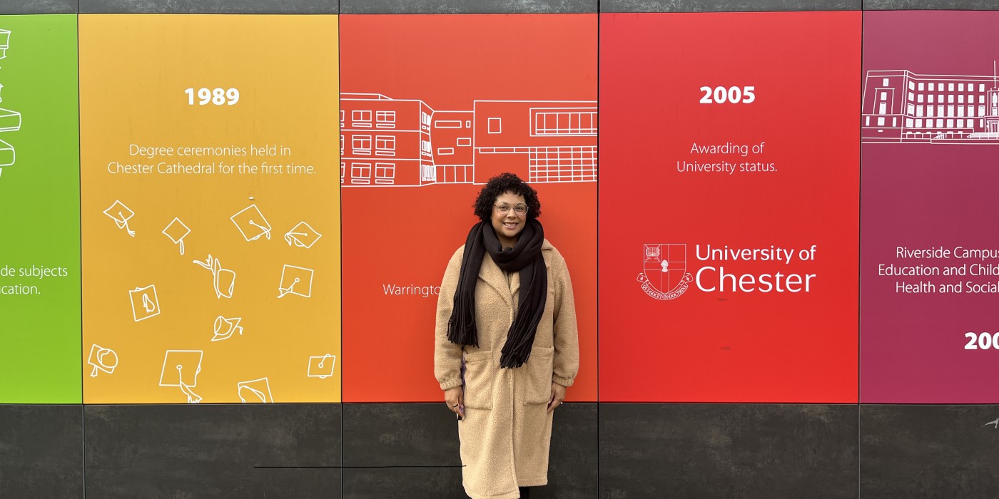 A mature student standing in front of one of the buildings on the main campus