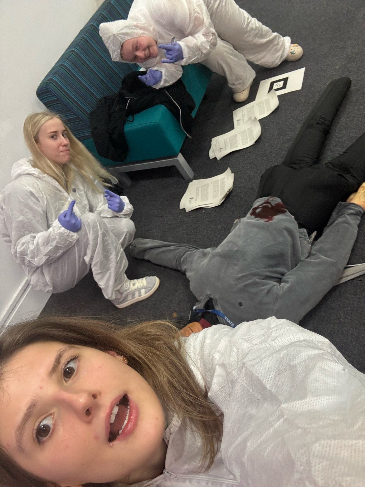 students dressed in outfits in front of a fake body on a crime scene day