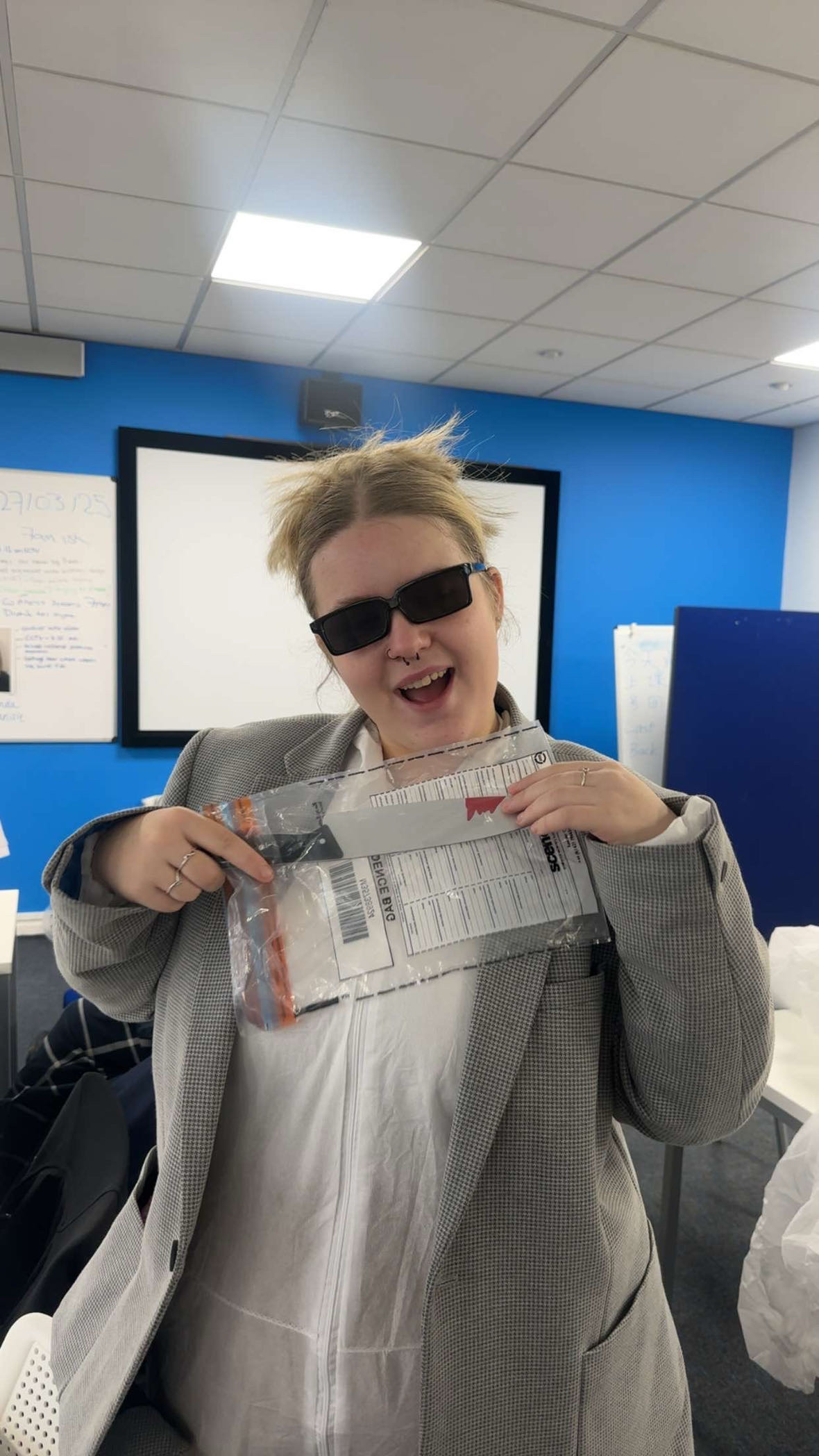 Student in deective outfit holding up evidence on a crime scene day
