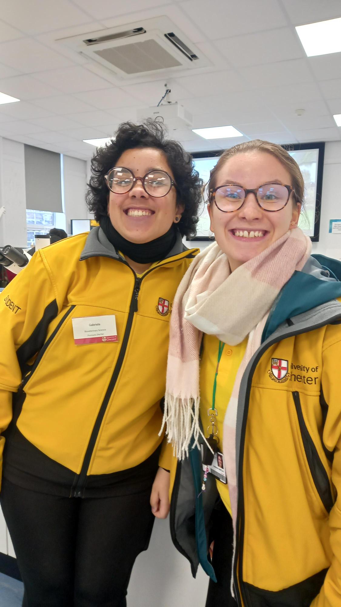 Two Student Ambassadors in yellow jackets, helping at Open Day