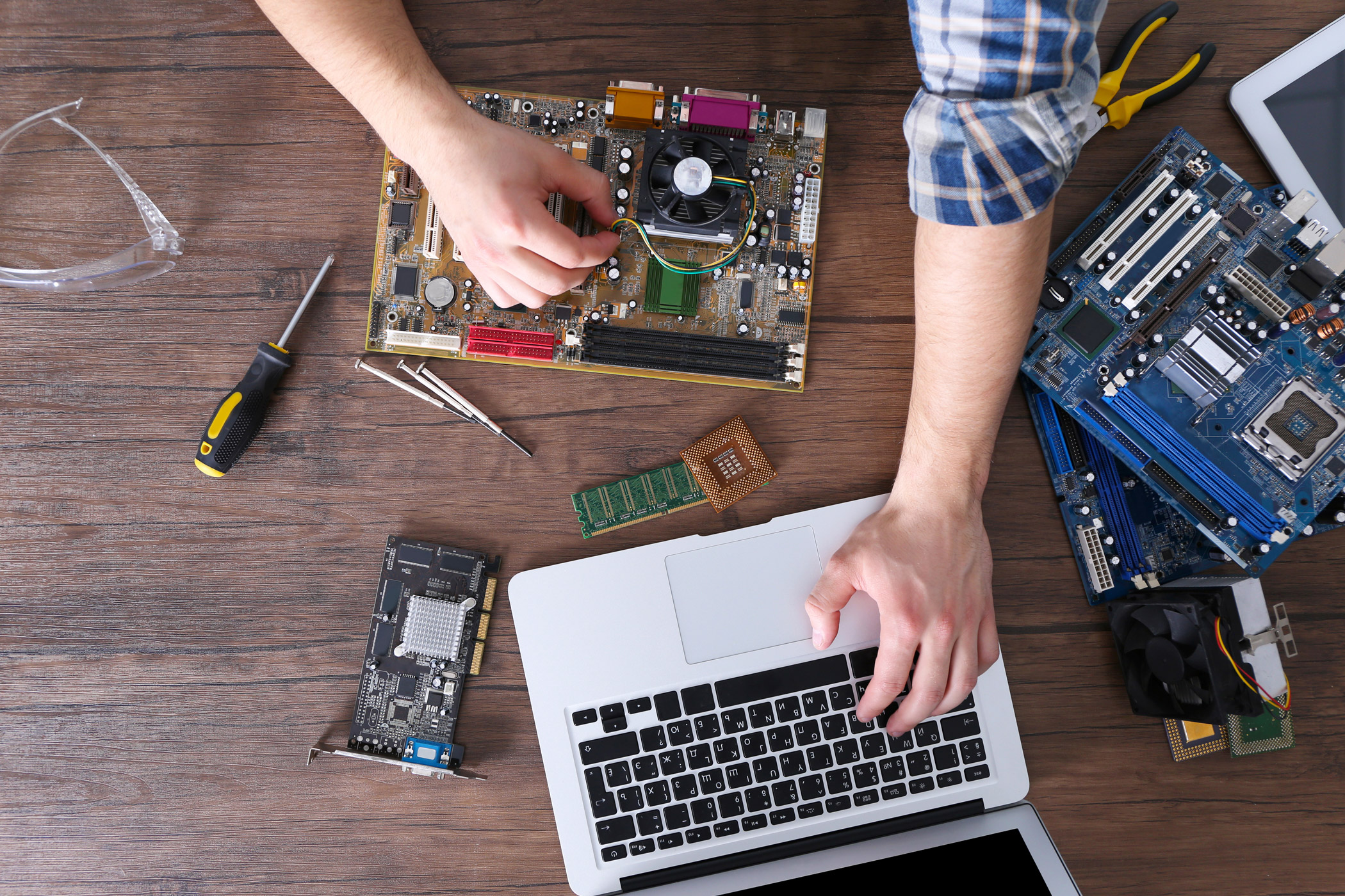 A person using an electronic device and a laptop