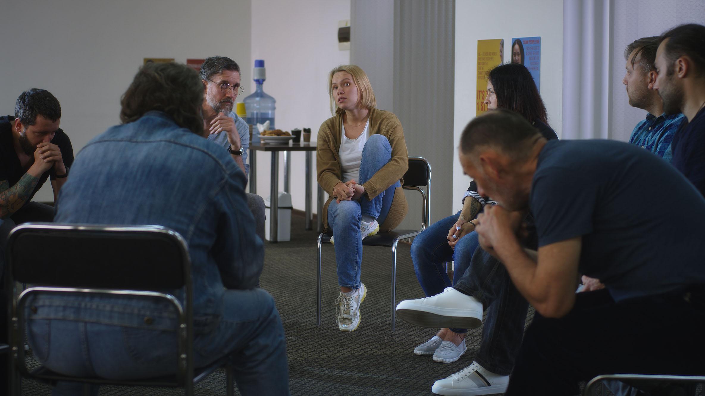A group therapy session with people discussing emotional experiences, representing the practical learning focus of a DProf in Trauma Psychology, Online course in Trauma Psychology, and Trauma Therapy Courses.