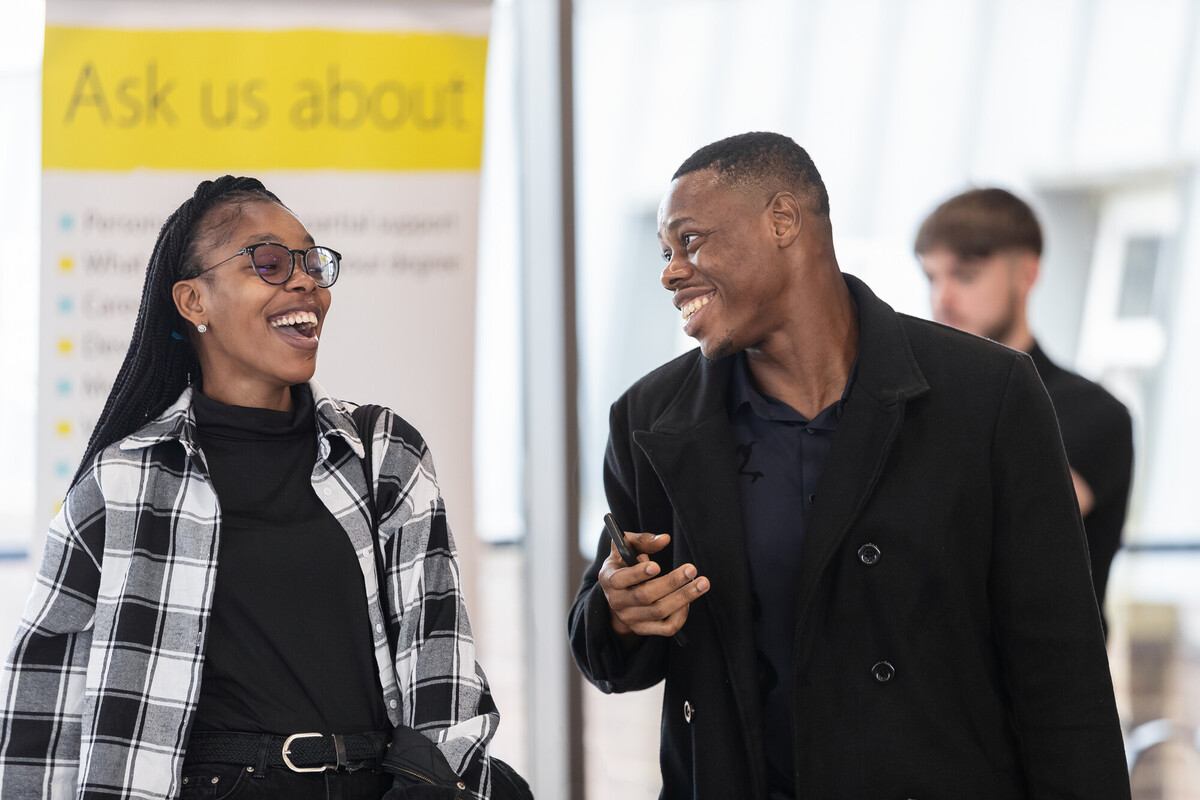 Two students walking together smiling and laughing with each other
