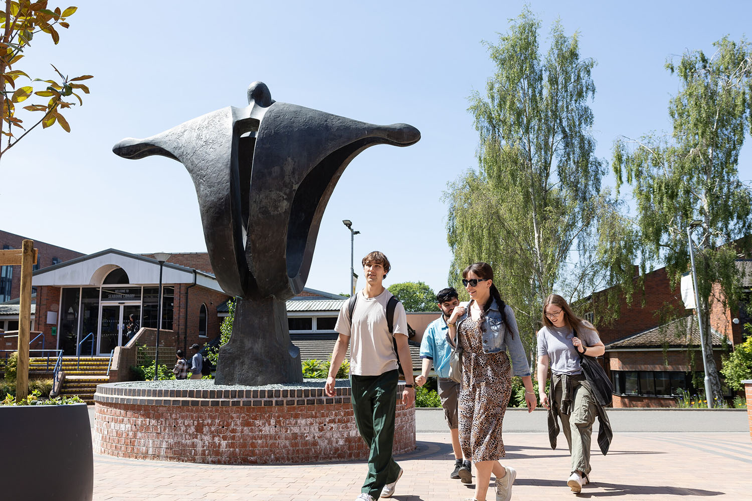 Students walking past the iconic sculpture at the University of Chester’s Exton Park campus on a sunny day.