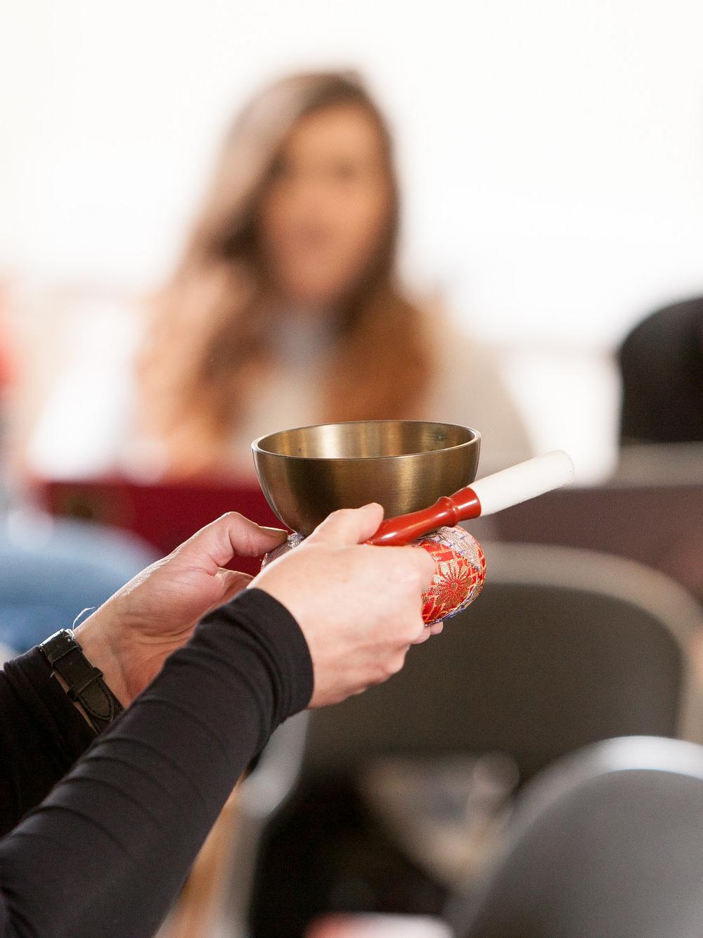 Student-led seminar on Theology and Religious Studies BA, featuring hands-on exploration of spiritual practices with a traditional singing bowl in a classroom setting.