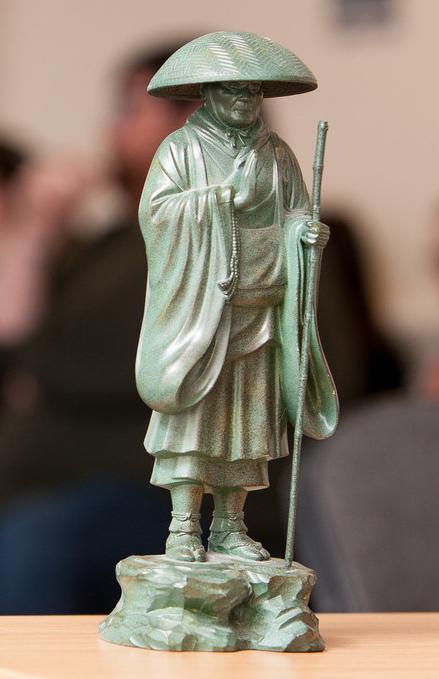 Philosophy, Ethics and Religion BA (Hons) students attending a university seminar with a statue of a Buddhist monk symbolizing spirituality, reflection and ethical study.
